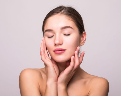 Pretty face of beautiful smiling woman - posing at studio isolated on white.